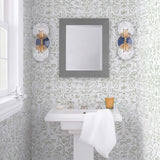 Storyline (Sage) Wallpaper | Folk art inspired pattern featuring flora and fauna in sage green on a soft gray ground