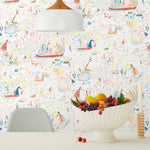 Detailed delights await discovery in Garden in the Sea Wallpaper - dancing mice, floating boats, sneaky snakes, swaying branches, and more. Hand-painted in red, green, blue, and yellow on a white background. Hillery Sproat + Hygge & West
