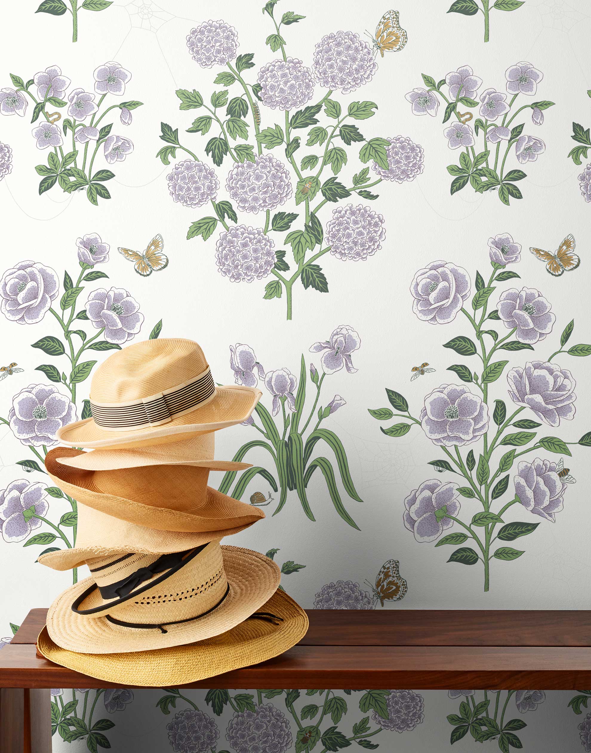 This large-scale wallpaper features hand drawn bees, butterflies and other garden friends frolic among flowers - camellias, hellebores, irises, and snowball trees. Harmony (Ebony) is printed in shades of green and purple on a white background.