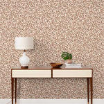 Olive Grove (Bellini) featuring a leafy vine motif in shades of rust and pink with green accents on an off white background | Schoolhouse x Hygge & West Wallpaper Collection