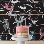 Balancing Act (Ebony) wallpaper features colorful dancing monkeys and rabbits on a black background
