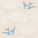 Daydream (Cream) features a pattern of flying birds and floating clouds in blue and white on cream