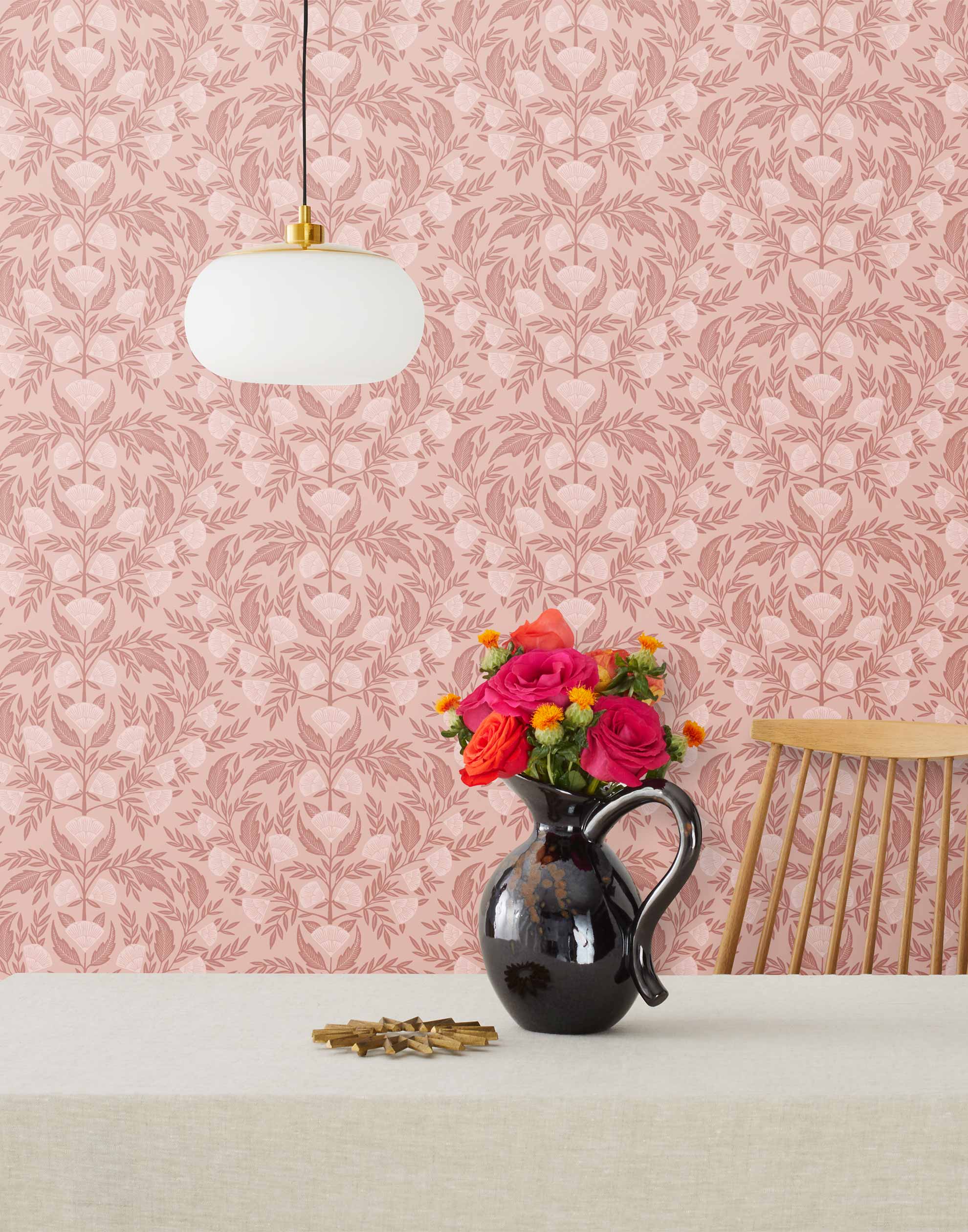 Symmetry wallpaper is a stylized floral wallpaper and designed in linocut style by Katharine Watson for Hygge & West | Dark pink and light pink flowers on a rose pink wallpaper background.
