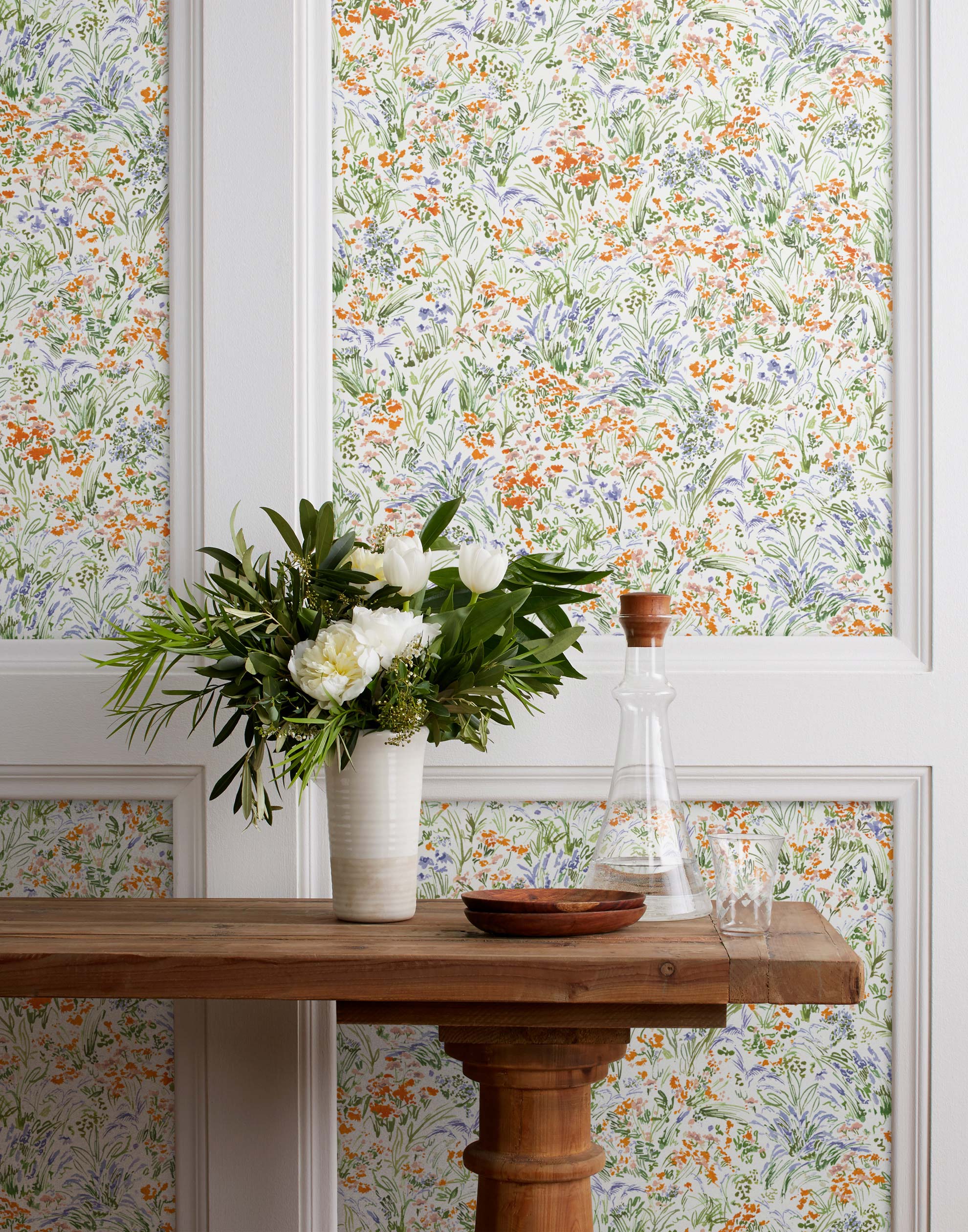 Summer (Bluebell) wallpaper features loose brushstrokes that capture the movement of wild flowers and grasses swaying in the breeze. Orange, blue, purple, and green watercolored flora on a white background | Hygge & West