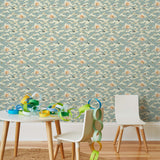 Amity Sunset (Sky) Wallpaper with dusty blue, cream and orange illustrations depicts scenes from the iconic movie Jaws and was created in collaboration with Universal | Hygge & West